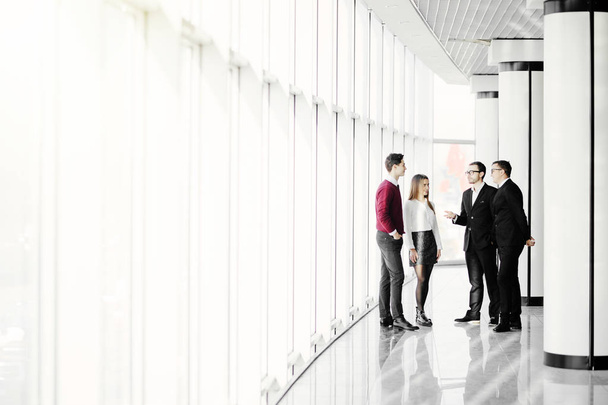 The business people walk in the office hall on the window background - Photo, image