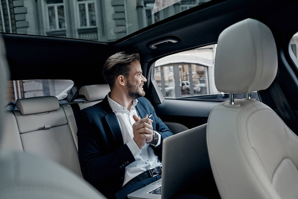 happy Handsome young businessman looking through the window while sitting in car - Фото, зображення