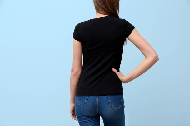 Young woman in black t-shirt on color background. Mockup for design - Foto, Imagem