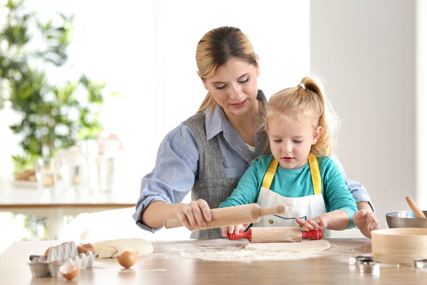 Mother and daughter with dough at table indoors - Foto, Imagem