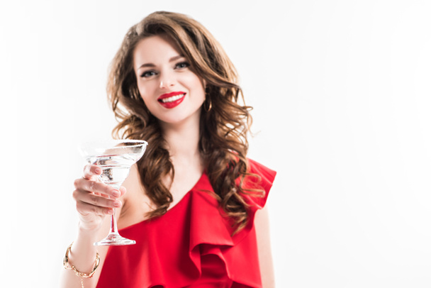 fashionable girl in red dress showing glass of cocktail isolated on white - Photo, Image