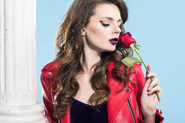 vonzó lány szippantás vörös rózsa kék, elszigetelt, a Valentin-nap koncepció   - Fotó, kép