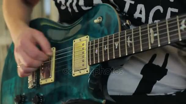 Um homem toca uma guitarra elétrica verde com um close-up
 - Filmagem, Vídeo