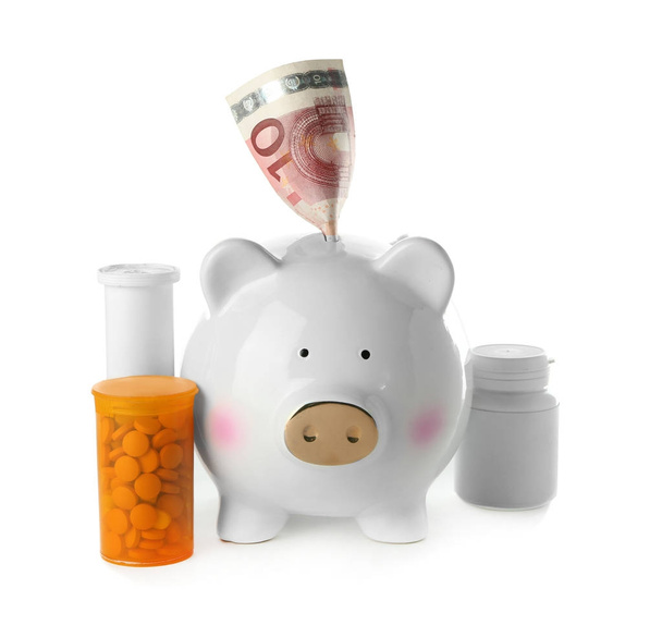 Piggy bank with banknote and pills on white background. Health care concept - Fotó, kép