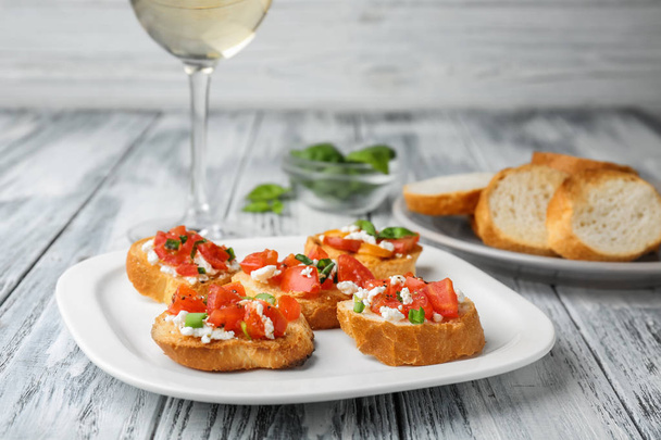 Tasty bruschettas with tomatoes on plate, closeup - Photo, Image