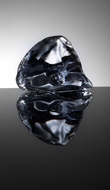 Yksi viileä jääkristalli vedellä peilitaustalla
 - Valokuva, kuva