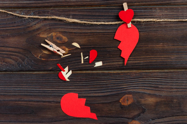 Gebroken hart uiteenvallen collectie en echtscheiding pictogram. Rood papier gevormd als een gescheurde liefde, gezondheidszorg problemen wegens ziekte. Gebroken liefde concept - Foto, afbeelding
