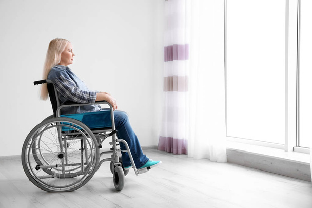 Mature woman in wheelchair indoors - Foto, imagen