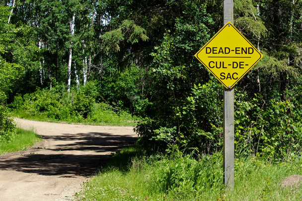 A Dead End sign beside a gravel road - Фото, изображение