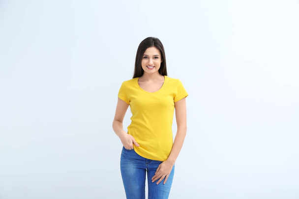 Young woman in color t-shirt on white background. Mockup for design - 写真・画像