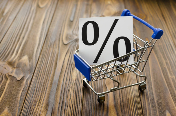 percentages in shopping cart on wooden background - Photo, Image