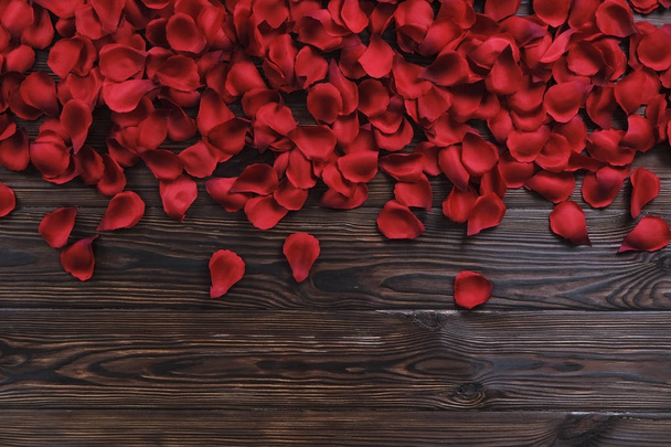 Beautiful bright red rose petals on wooden background. Happy valentines day oliday sales concept. - 写真・画像