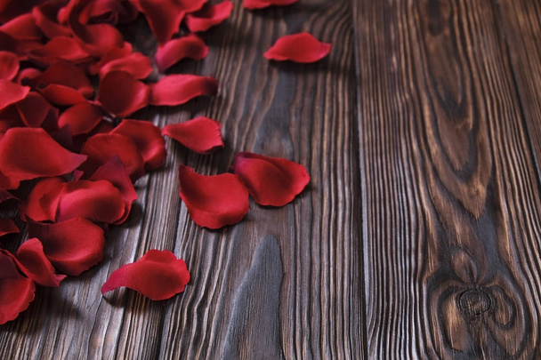 Beautiful bright red rose petals on wooden background. Happy valentines day oliday sales concept. - 写真・画像
