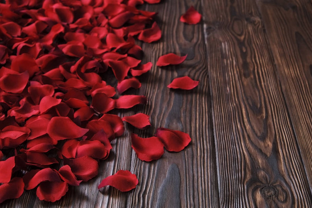Beautiful bright red rose petals on wooden background. Happy valentines day oliday sales concept. - Zdjęcie, obraz