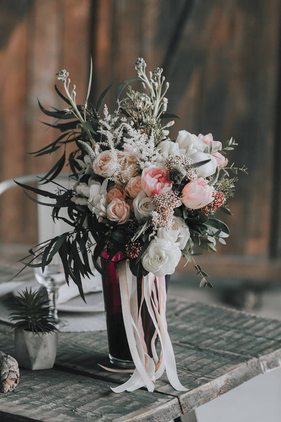Wedding bouquet with white and pink roses and other flowers on a rustic table. Artwork. Indoors. - Photo, image