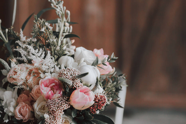 Flower composition with white and pink roses and other flowers on a rustic table. Artwork. Indoors. - Photo, image