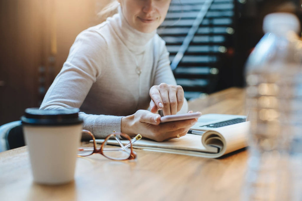 Primo piano di donna immagine puntando il dito sullo smartphone schermo mentre si lavora in caffè
 - Foto, immagini