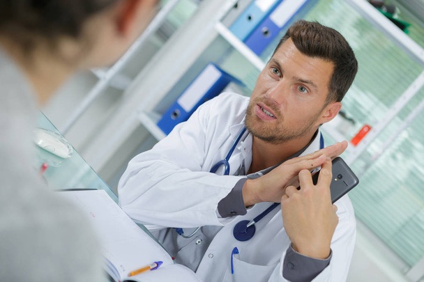 médico informa o paciente sobre os resultados da pesquisa de raios-x por telefone
 - Foto, Imagem