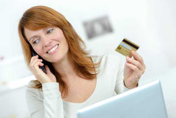 mooie vrouw met credit card en laptop op de Bank - Foto, afbeelding