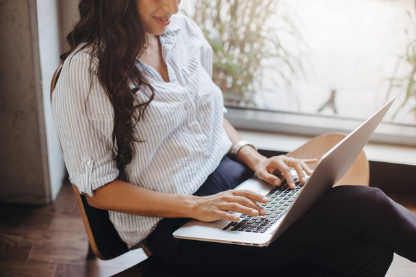 Обрезанный образ профессиональной предпринимательницы, работающей в офисе с помощью ноутбука
 - Фото, изображение
