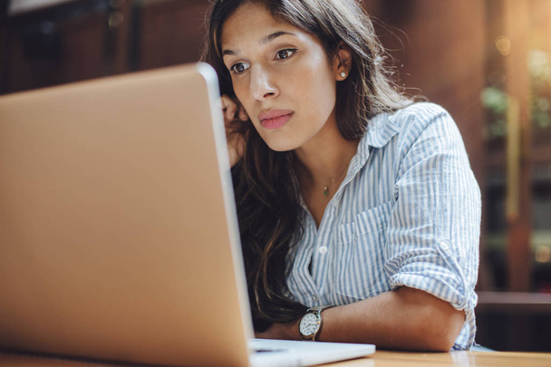 Portrait of confident woman working on laptop - Foto, afbeelding