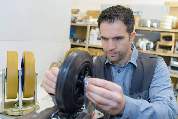 mechanic repairing wheels and fixing - Foto, afbeelding