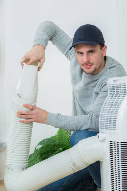 young technician installing air conditioning system indoors - Φωτογραφία, εικόνα