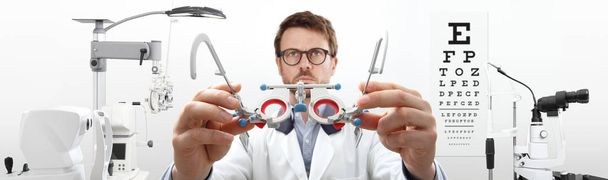Optikerhände mit Versuchsrahmen, Augenarzt untersucht Auge - Foto, Bild