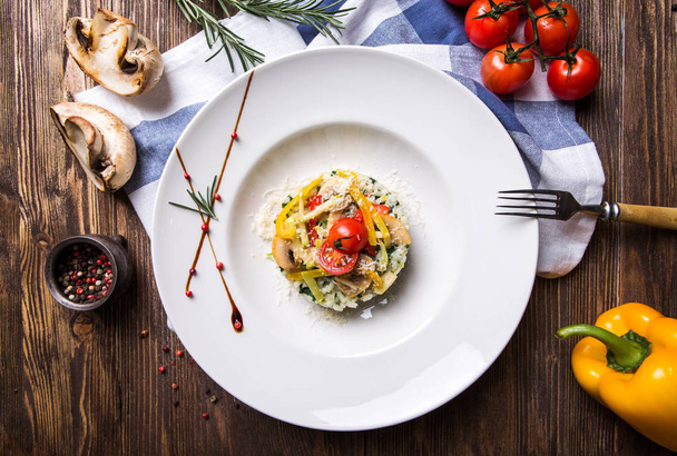 Risotto aux légumes et champignons dans une assiette blanche sur une sombre
 - Photo, image