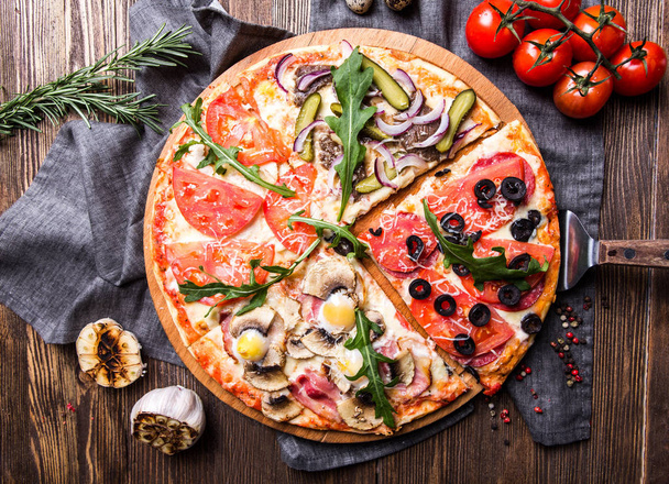 Вкусная итальянская пицца на темном деревянном фоне сверху
 - Фото, изображение