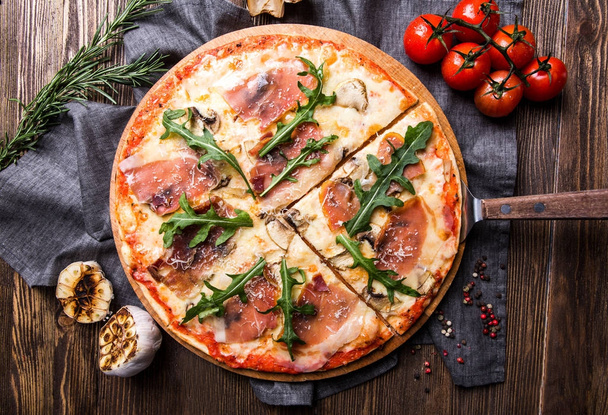 Savoureuse pizza italienne sur un fond en bois sombre vue de dessus
 - Photo, image