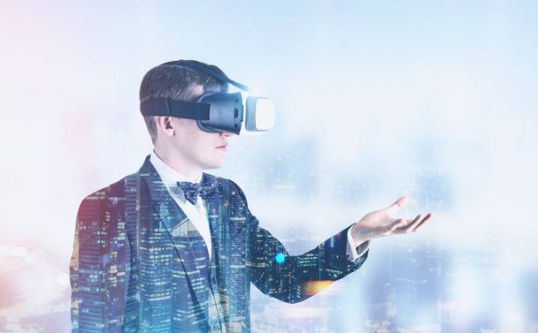 Businessman in VR glasses in a night city - Фото, изображение