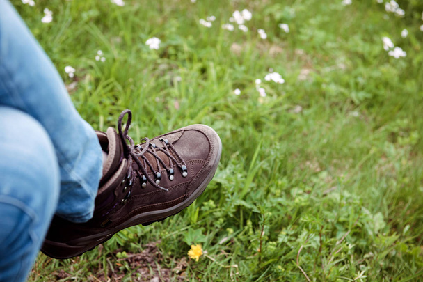 Horizontální podoba překřížené ženských nohou, nosit Alpine Touring Randonee boty na nohách žena v zelené horské oblasti. - Fotografie, Obrázek
