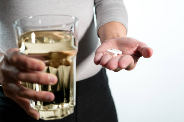 水、薬回復概念のガラスと薬を持っている女性手の分離します。 - 写真・画像