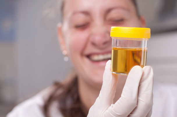 Frau untersucht Urin-Behälter - Foto, Bild