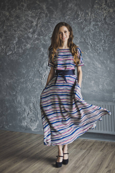Gorgeous slender girl in a striped dress 6983. - Foto, immagini