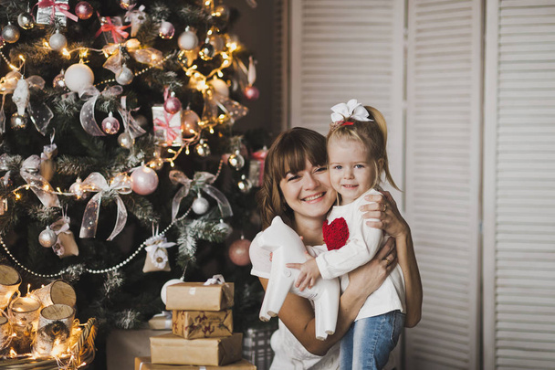 Happy mother and daughter playing on the background of Christmas - Photo, Image
