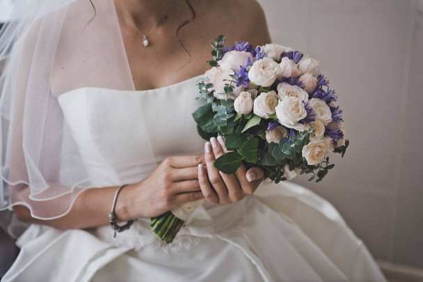 The bride holds a delicate bouquet of flowers 7694. - Фото, изображение