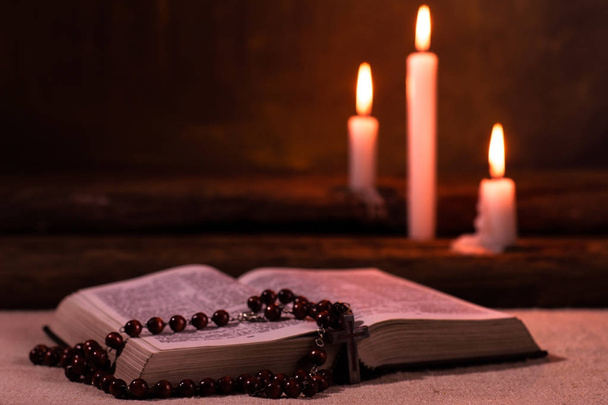 Біблія і свічка на старому дубовому дерев'яному столі. Гарний золотий фон. Концепція релігії
. - Фото, зображення
