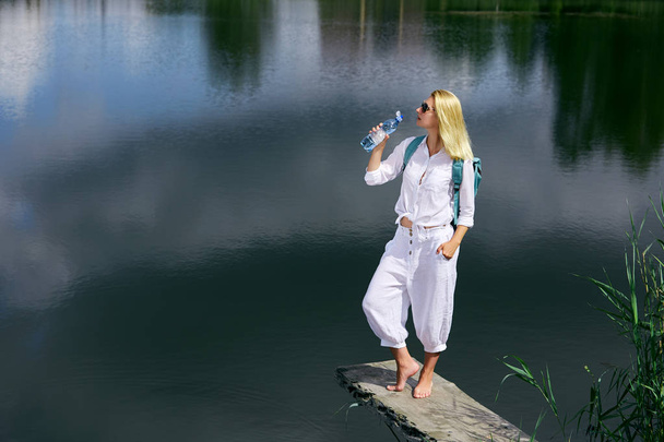 junge Frau rastet in der Nähe des Sees aus - Foto, Bild