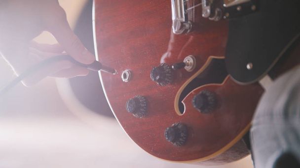Musician disables guitar after a performance, hands close up - Photo, Image