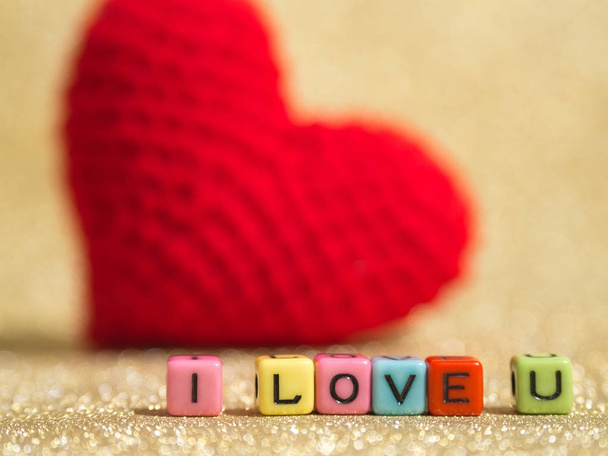 Rode garen hart met I Love You tekst uit kleurrijke kraal op de gouden woord en de achtergrond kopie ruimte voor tekst. Valentijnsdag, liefde concept en liefde achtergrond - Foto, afbeelding
