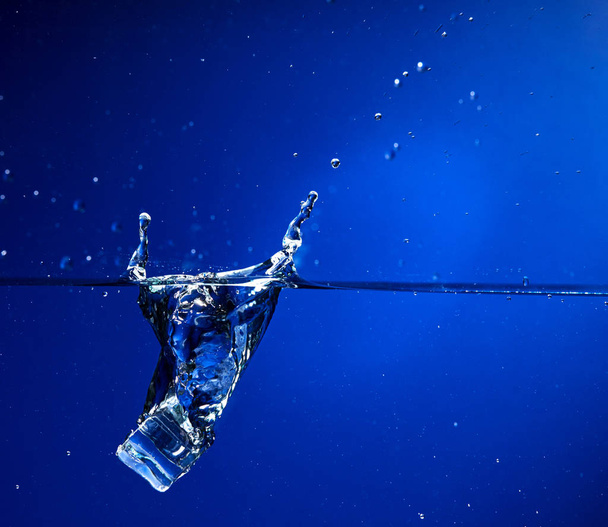 cubo de hielo cayendo en el agua, primer plano
  - Foto, Imagen