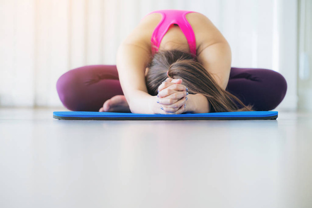 Young woman exercising stretching back yoga pose - Foto, Bild