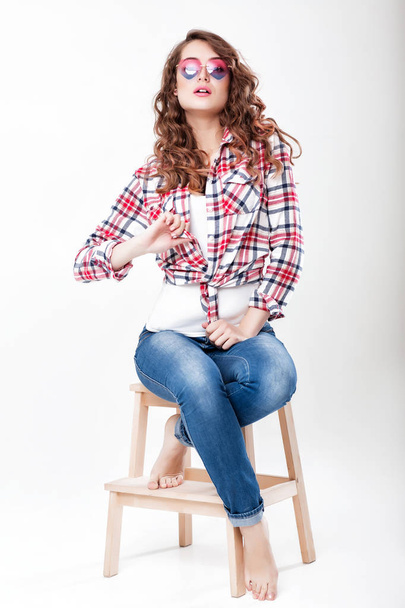 woman in jeans, plaid shirt and sunglasses - Foto, afbeelding