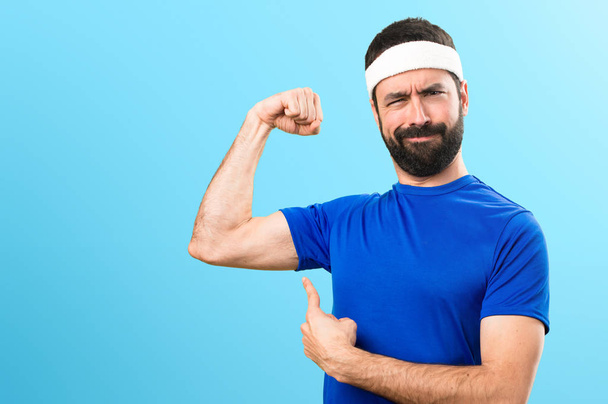 Funny sportsman making strong gesture on colorful background - Foto, afbeelding