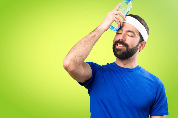 Deportista divertido con una botella de agua sobre fondo colorido
 - Foto, imagen