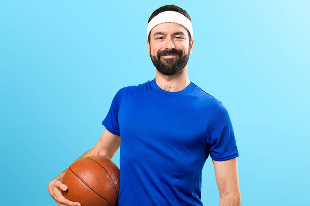 Boldog vicces sportember, a labda a kosárlabda, a színes háttérben - Fotó, kép