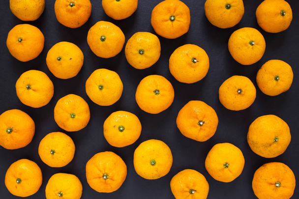 Fresh orange tangerines on black background. Oranges on table top view photo. Fresh oranges photo backdrop. Juicy citrus fruit top view. Winter seasonal fruit. Oranges banner template. Vitamin food - Photo, Image