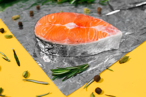 Composition on a yellow background with red fish, rosemary and leek - Foto, Bild